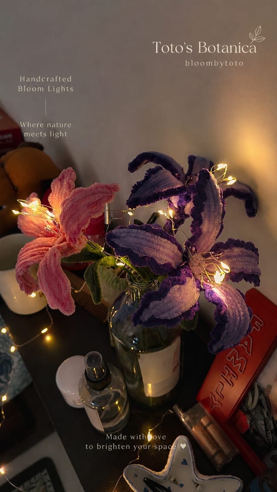 Crochet lilies wrapped in warm fairy lights, glowing in a softly lit room.